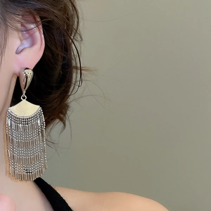 Close-up of elegant silver fan-shaped tassel earrings on model with high gloss finish