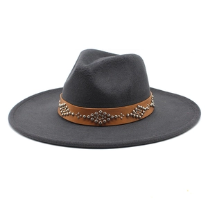 Dettaglio di cappello fedora in lana grigio scuro con cinturino in pelle e borchie