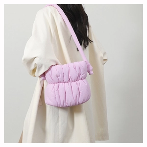Rear view of a pink puffy nylon bucket bag showing soft pleated texture and shoulder strap