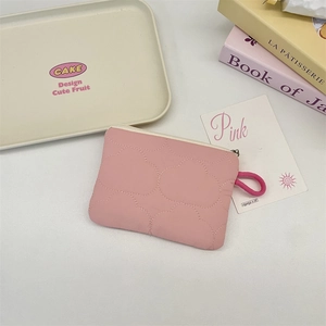 Close-up of pink quilted cloud coin purse with white zipper and portable wrist strap