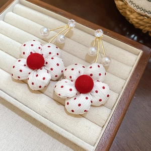 Detail of flower earrings with red polka dots fabric petals and sparkling crystal accents