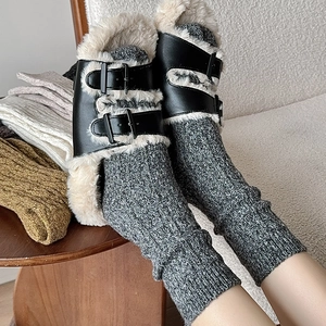 Winter set with grey wool socks and black fur-lined buckle mules in a cozy home setting