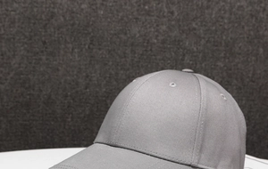 Close-up of gray cotton twill fabric texture and embroidered vents on the baseball cap