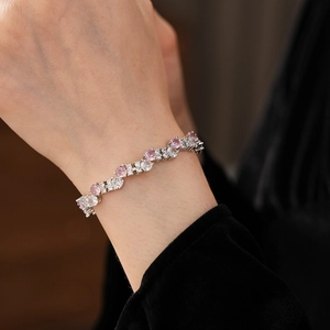 Close-up of zircon bracelet with pink and white stones on wrist in silver finish