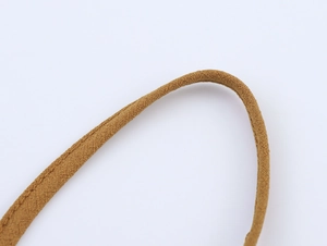 Vue macro d'une sangle en tissu tressé marron montrant les détails du tissage serré