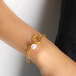 Elegante bracciale con perla dorata e chiusura a levetta per uno stile di lusso