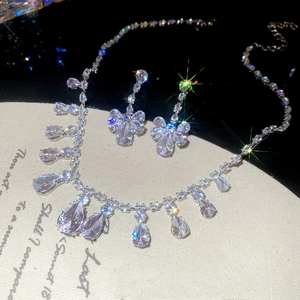 Detail view of silver zircon water drop tassel necklace and floral earrings set