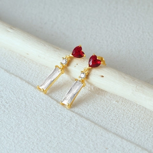 Macro shot of s925 silver vintage earrings with red heart stones and gold star details