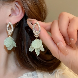 Detail of sweet green floral drop earrings with sparkling zircon and matte petals