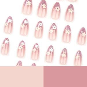 Pink gradient press-on nails with purple glitter tips and white flower decorations