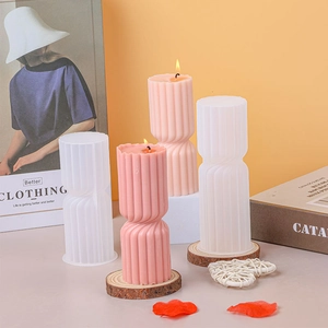 Detailed view of vertical striped candle molds and finished pink textured candles