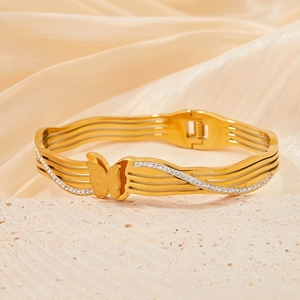 Elegant gold butterfly bangle with frosted wings and sparkling diamonds on a silk background