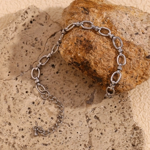 Macro view of silver stainless steel chain bracelet with oval links and teardrop pendant