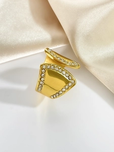 Detailansicht eines vergoldeten 18K Rings mit Strasssteinen auf beiger Seide