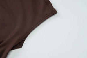 Dettaglio delle cuciture doppie sul polsino di un abito corto in maglia marrone