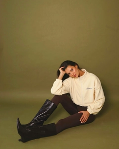 Detail of embroidered Amkers lettering on beige fleece jacket with zipper and stand collar
