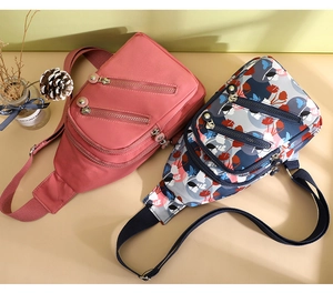 Detail view of pink and floral nylon cross-body bags with multiple zipper pockets