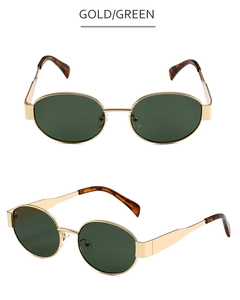 Detail view of oval sunglasses with gold metal frame, green lenses, and tortoiseshell tips