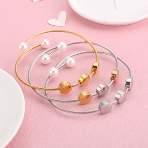 Three-color wire bangle bracelets in gold, silver, and rose gold with pearl details