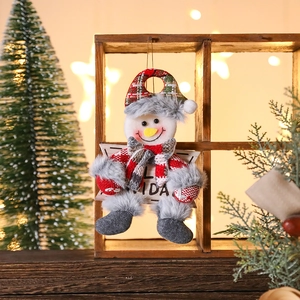 Detail of plush snowman ornament with Feliz Navidad sign and red plaid festive accessories