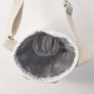 Detail of insulated silver lining and beige quilted fabric on kids water bottle bag