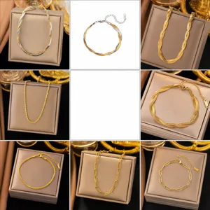 Detail of 18K gold plated jewelry set featuring snake bone and paperclip chain necklaces