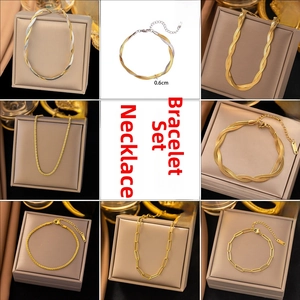 Detail of 18K gold plated jewelry set featuring snake bone and paperclip chain necklaces
