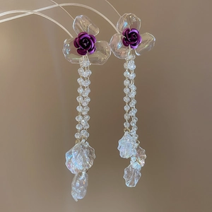 Close-up of elegant purple rose earrings with crystal beads and iridescent petals
