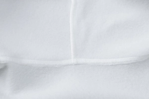 Detailed macro view of white fleece fabric texture and high-quality stitching on jacket