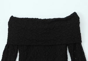 Gros plan sur la dentelle noire élégante et l'encolure bardot de la robe moulante chic