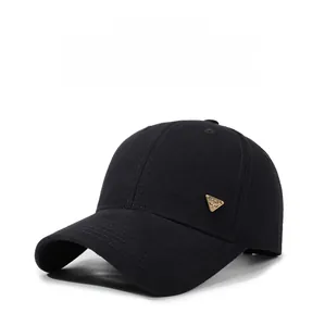 Detailed close-up of a black baseball cap with a gold SPIRIT triangle metal badge
