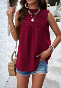 Detail view of wine red sleeveless blouse with lace crochet and textured dot fabric
