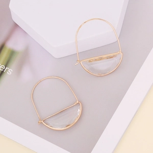 Golden D-shaped geometric drop earrings with frosted glass inlay on a minimal background
