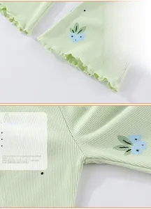 Détails du pantalon en maille côtelée vert clair avec imprimé floral et bords ondulés