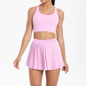 Pink yoga set featuring a racerback sports bra and pleated tennis skirt in high-stretch fabric