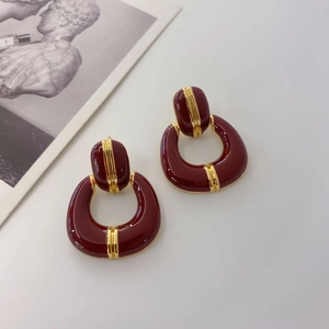 Macro view of vintage horseshoe earrings with deep red enamel and gold-plated finish