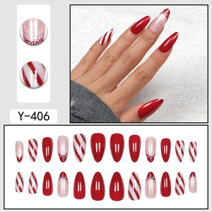 Christmas almond press-on nails with red white candy stripes and snowflake designs