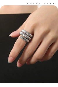 Detailansicht eines silbernen Titanstahlrings mit Wellenstruktur und Mikro-Diamanten