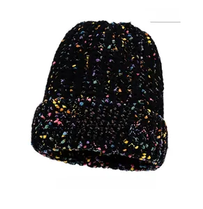 Close-up of black chunky knit beanie featuring colorful speckles and white fabric label