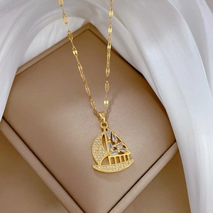 Elegant gold titanium steel sailboat necklace with white zircon crystals on silk fabric