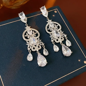 Macro detail of vintage baroque silver earrings with zircon waterdrop tassels in a gift box