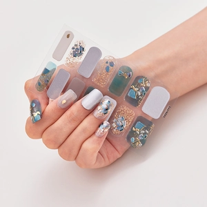 Detail of laser gold nail stickers with blue shell flakes and grey solid color finish
