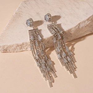 Detailed view of silver tassel earrings with light blue zircon on stone display
