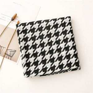 Detail shot of black and white houndstooth scarf texture with high-quality woven edges