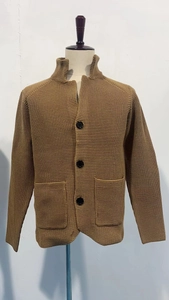 Detail of brown waffle knit cardigan showing black buttons, pockets and thick texture
