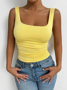 Slim fit yellow knitted square neck tank top for women paired with blue denim jeans