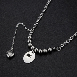 Vue détaillée du collier argenté avec pendentifs en forme d'étoile ovale et de cœur