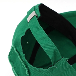 Detail of green distressed baseball cap showing adjustable silver buckle and cotton texture