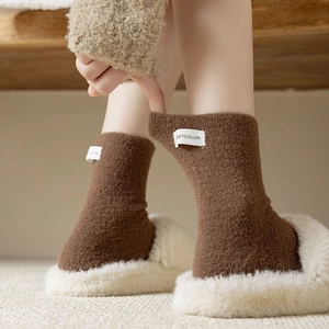 Detail of brown knitted thermal socks with white woven label showing soft texture