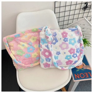 Close-up of plush floral tote bags in pink and white soft fabric on a chair